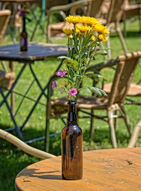 yellow flowers in a brown beer bottle