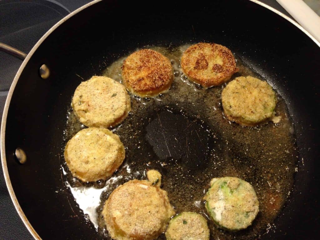 Fried green tomatoes frying in pan