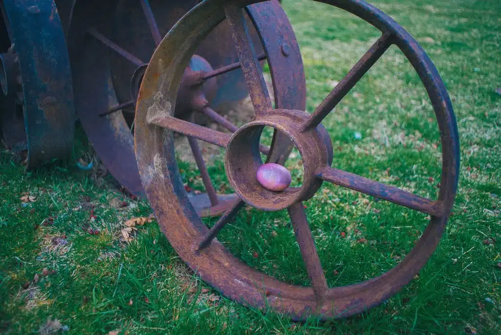 Pink Easter egg on old rusty wagon wheel