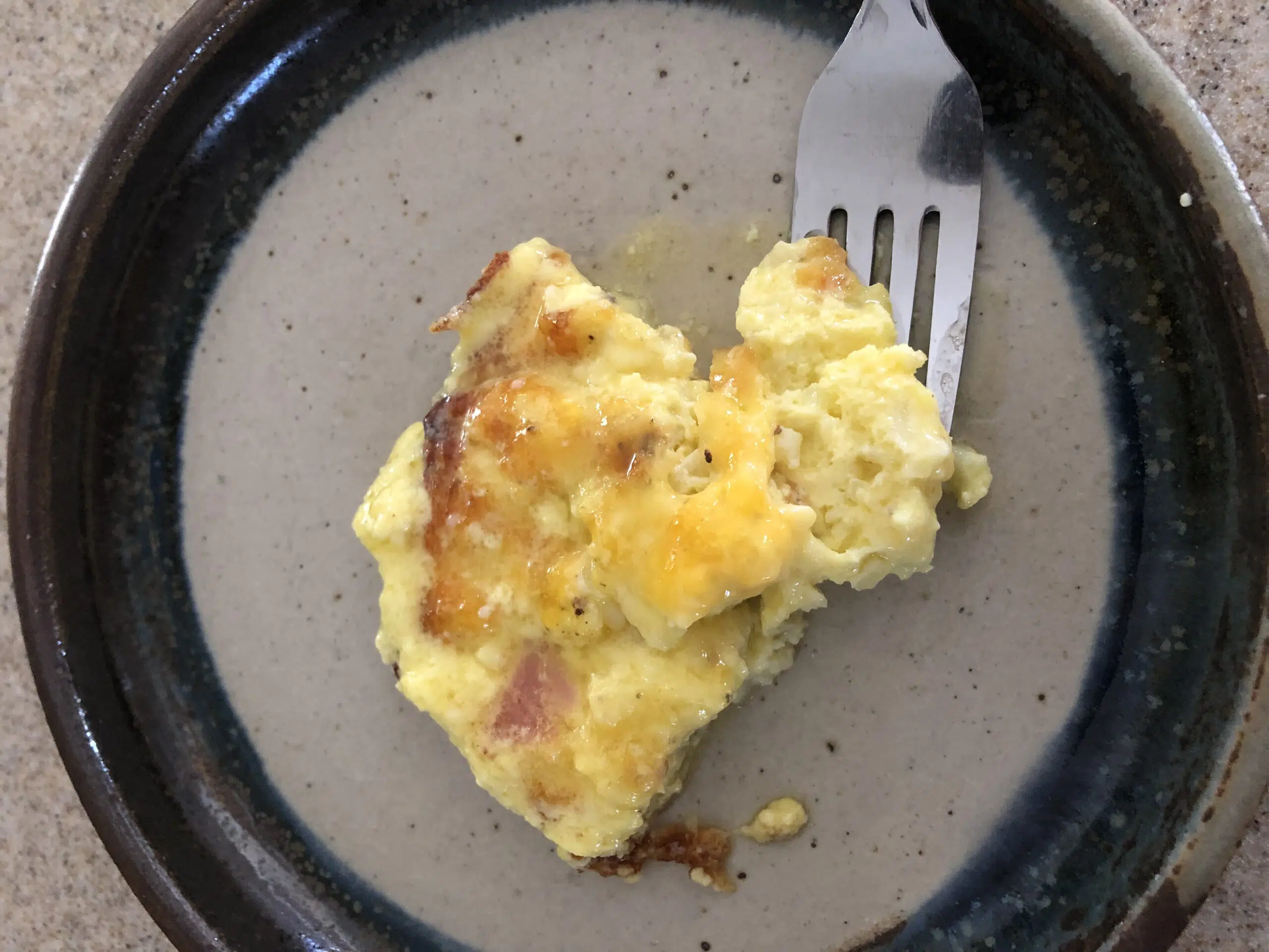 keto eggs benedict on stoneware plate with fork