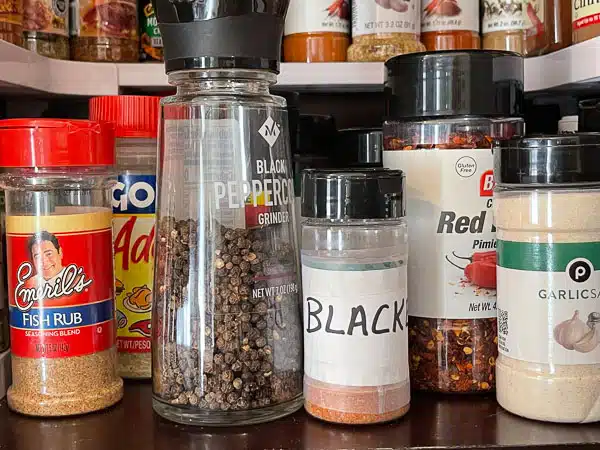 several containers of seasonings in a cupboard
