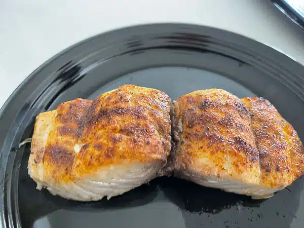 fish on a black plate with blackened seasoning