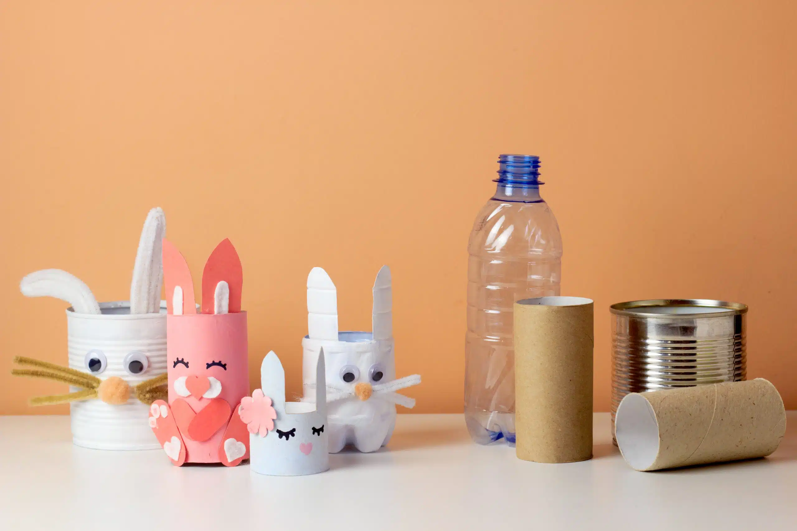 Reuse concept art from tin can, toilet tube, plastic bottle. Eco friendly bunny craft. Handmade decoration easter rabbit. Kids DIY ideas