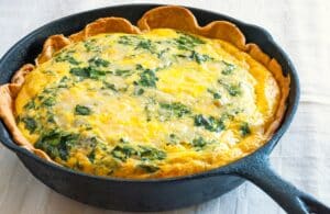 spinach mushroom quiche in a black cast iron frying pan