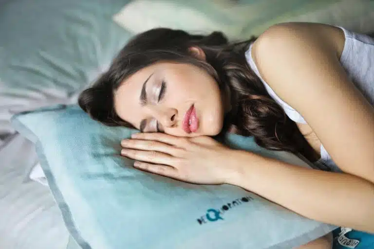 woman sleeping on side on blue pillow