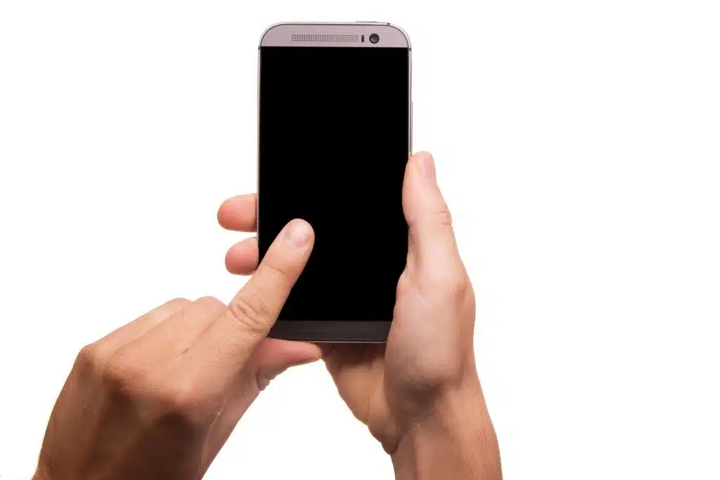 cell phone with black screen and person holding it