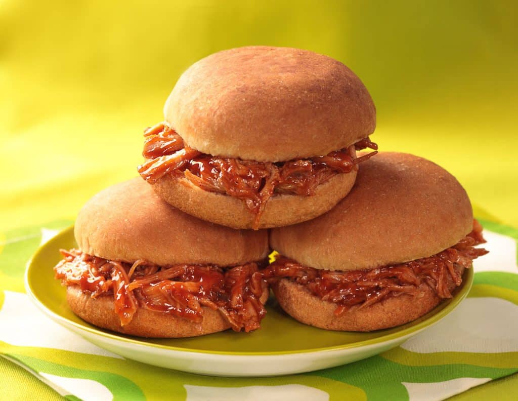 3 BBQ turkey sliders stacked on a green plate