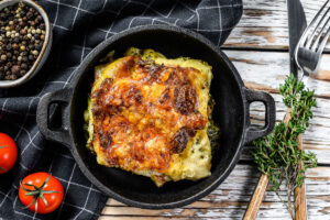 Delicious baked lasagna in a pan, Italian traditional cuisine. White wooden background. Top view.