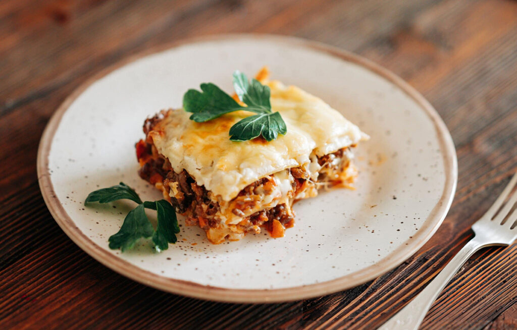 piece of Mexican lasagna with basil on white plate