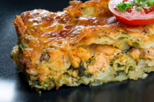 a serving of salmon lasagna with layers of noodles, salmon, and melted cheese on top