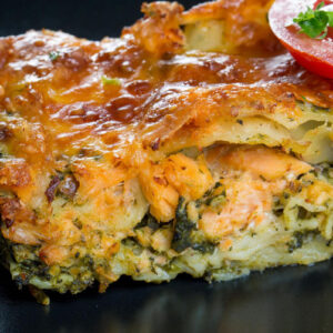 a serving of salmon lasagna with layers of noodles, salmon, and melted cheese on top