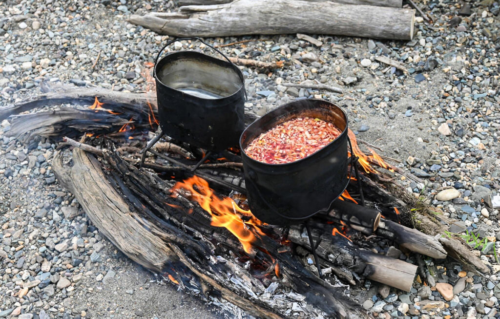 campfire red beans and rice in black pots on open flame fire