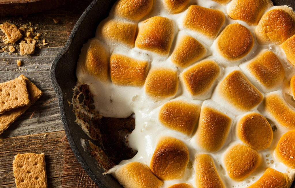 S'mores dip with toasted marshmallows in black frying pan