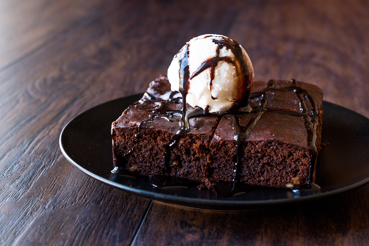 chewy fudge brownies with drizzled chocolate sauce and vanilla ice cream