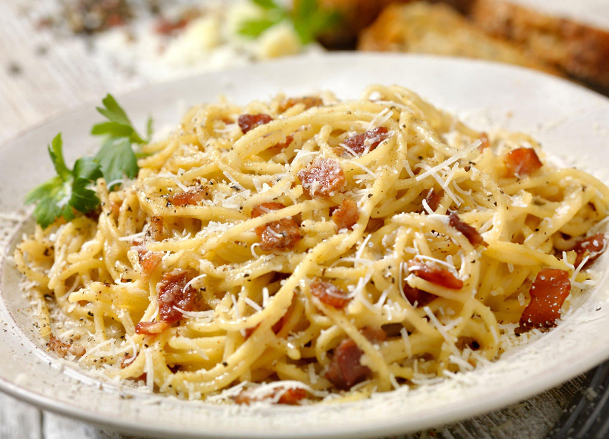 spaghetti carbonara with cheese on white plate