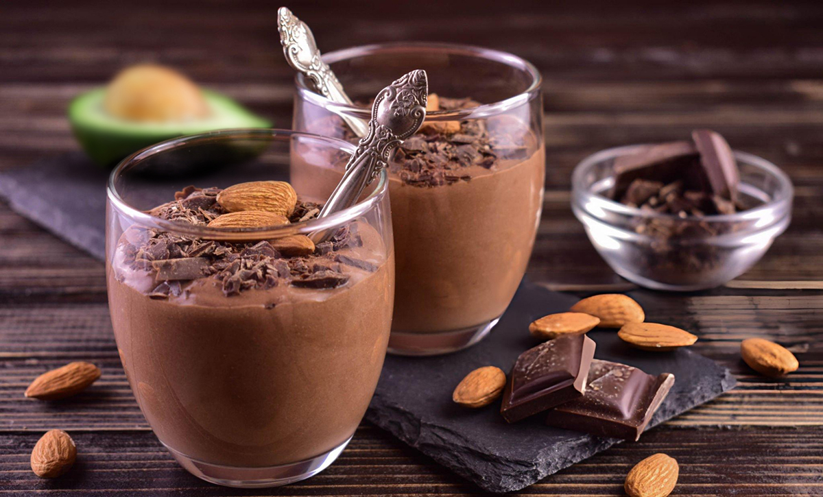 two chocolate avocado mousse cups in small glasses