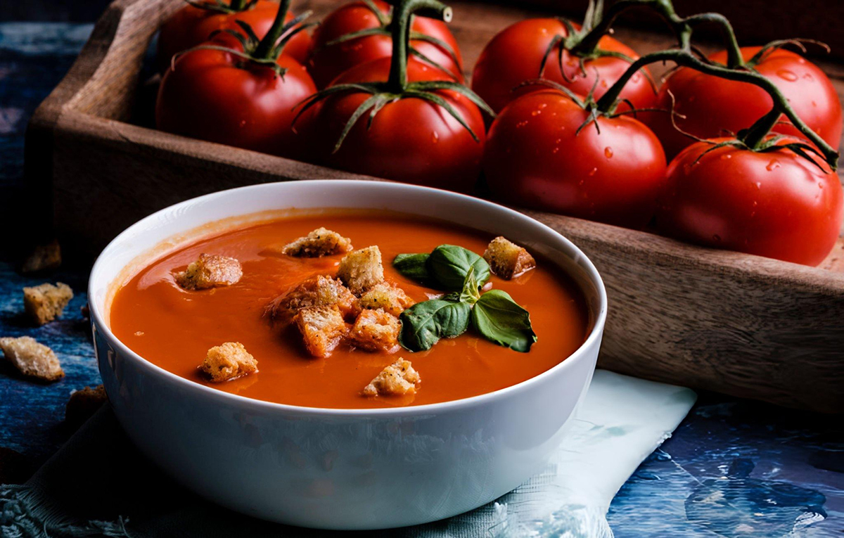 red tomato basil soup in light blue bowl