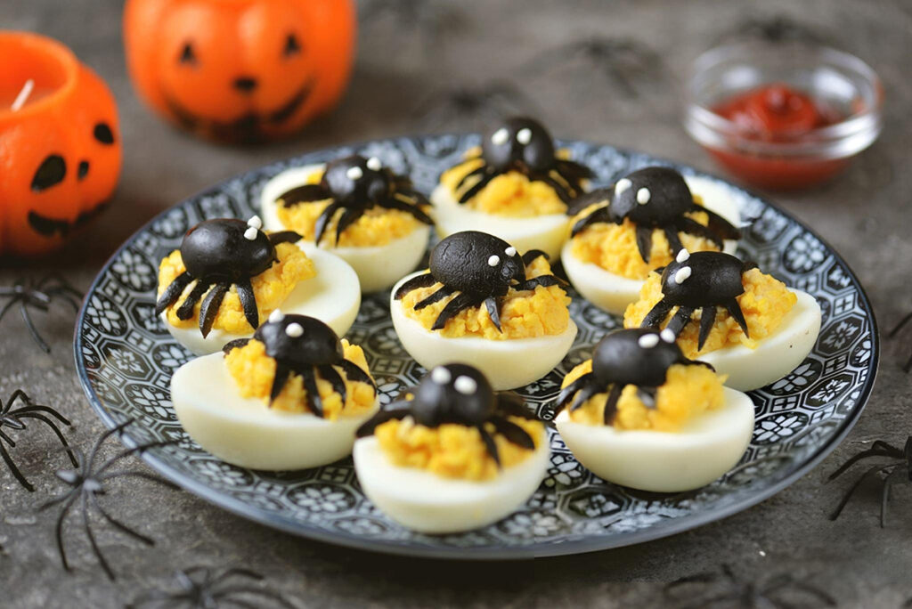 deviled eggs with spiders on top