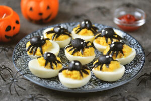 deviled eggs with spiders on top