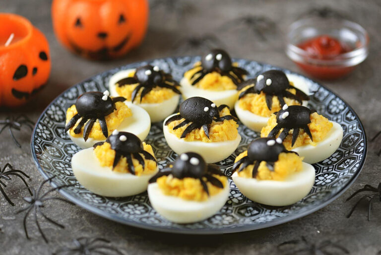 deviled eggs with spiders on top